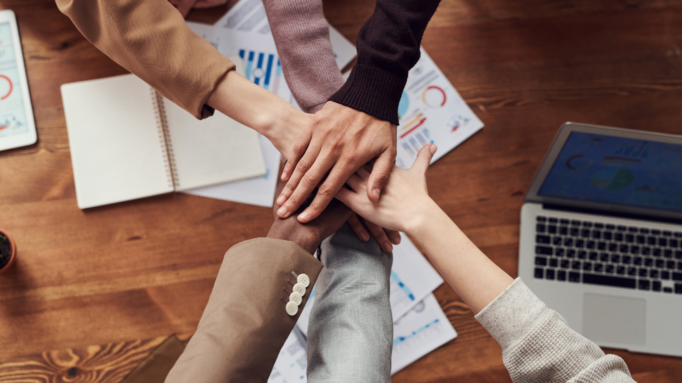 Many people joining hands in a business marketing firm