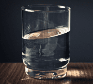 Glass kept on a table, dark background.
